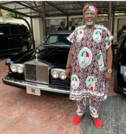 This is a photograph of Dino Melaye, on the right, wearing a PDP Agbada in front of a black Rolls Royce.